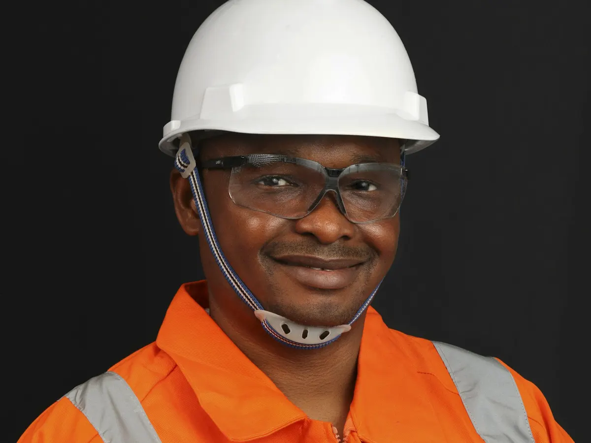 Field engineer in a hard hat, safety glasses and high-visibility jacket